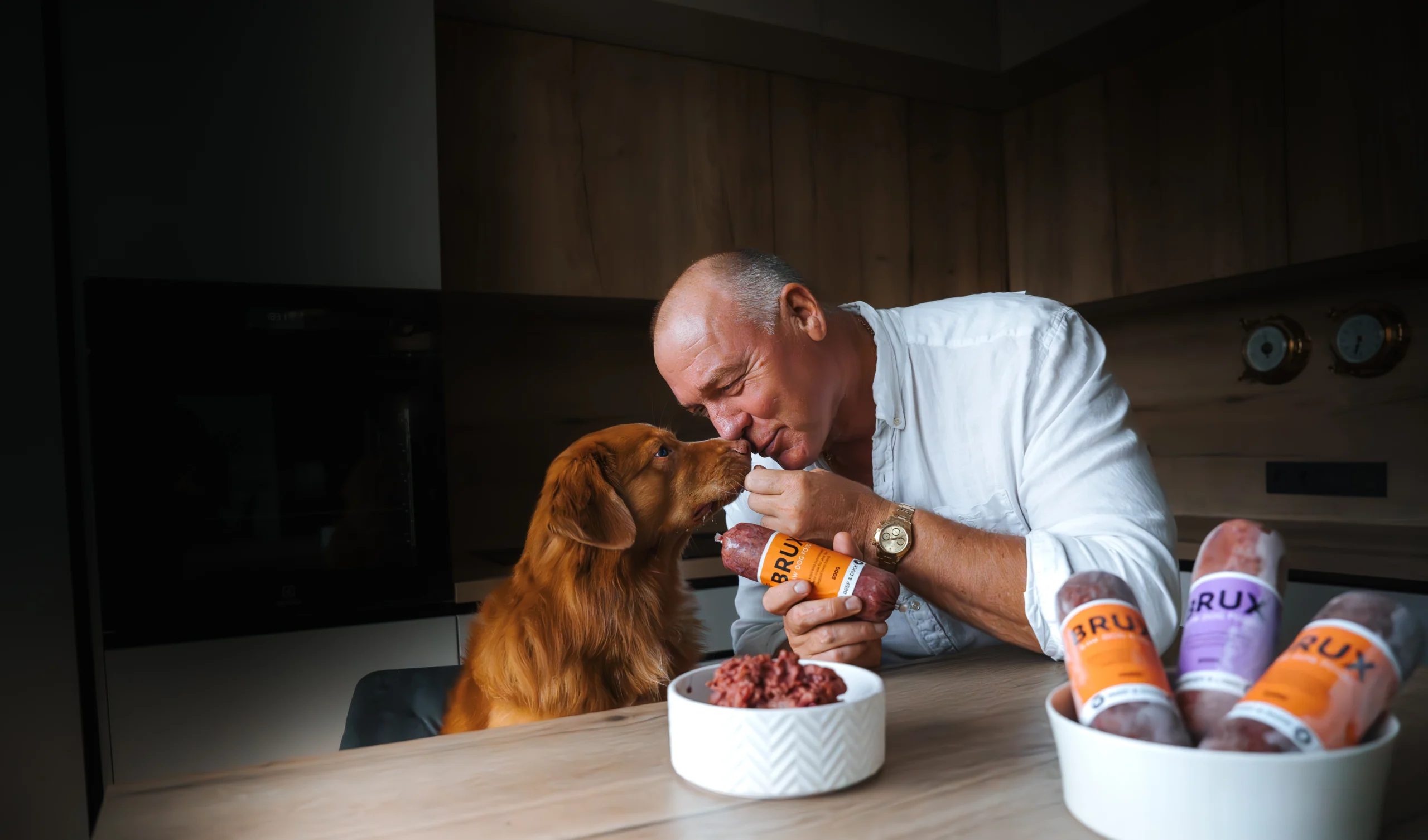 Man and his nova scotia duck tolling retriever with BRUX raw dog food